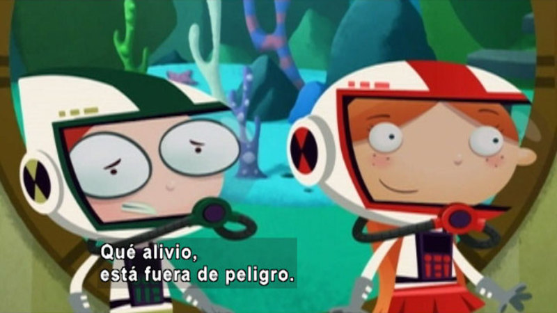 Two cartoon characters wearing scuba gear in front of a large porthole. Spanish captions.