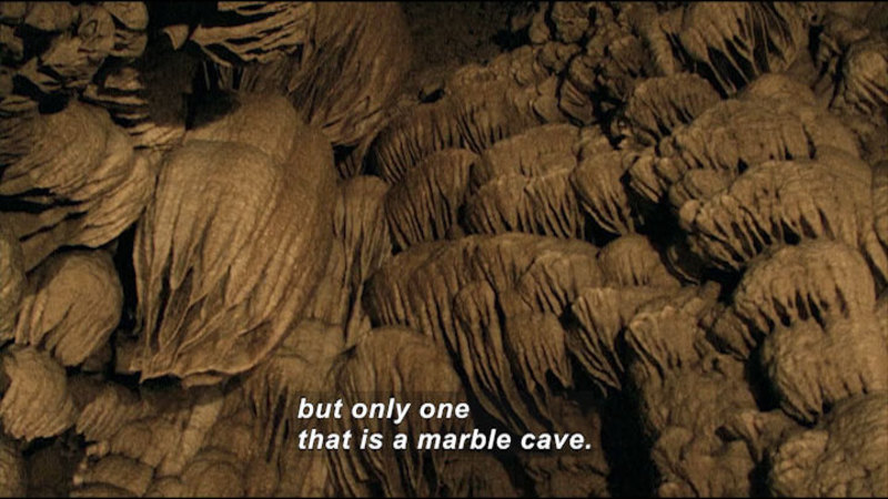 Domed, dripping rock structures line the wall of a cave. Caption: but only one that is a marble cave.