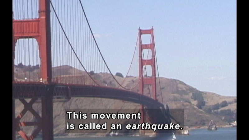 Rolling brown foothills ending in San Francisco Bay with the Golden Gate bridge in the foreground. Caption: This movement is called an earthquake.