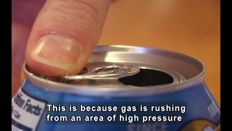 Open aluminum can. Caption: This is because gas is rushing from an area of high pressure