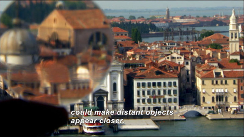 Round transparent object magnifying a section of a cityscape. Caption: could make distant objects appear closer.