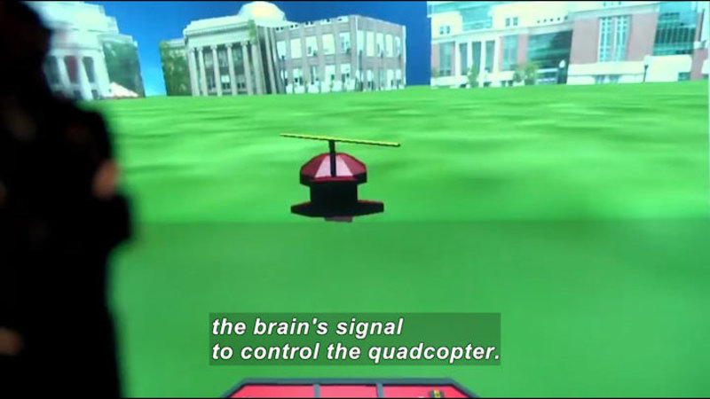 3D graphic of a mostly cylindrical object with a rotor on top against a backdrop of grass and buildings. Caption: the brain's signal to control the quadcopter.