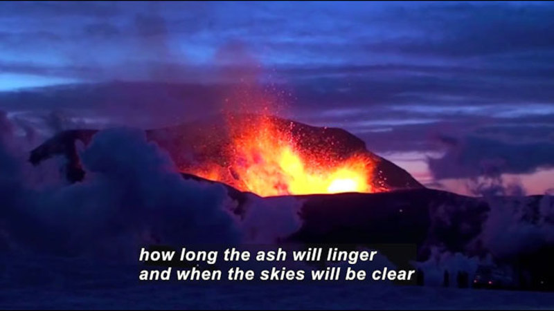 Lava spewing from a crevasse while smoke and ash rises around it. Caption: how long the ash will linger and when the skies will be clear
