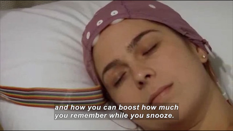 Person with head laying on pillow while wearing a cap with wires attached. Caption: and how you can boost how much you remember while you snooze.