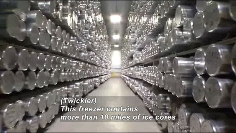 Stacked shelves of cylindrical metal canisters. Caption: (Twickler) This freezer contains more than 10 miles of ice cores