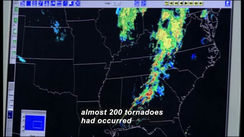 Computer screen showing east coast of United States with color gradient showing a band of storms parallel to the coastline. Caption: almost 200 tornadoes had occurred