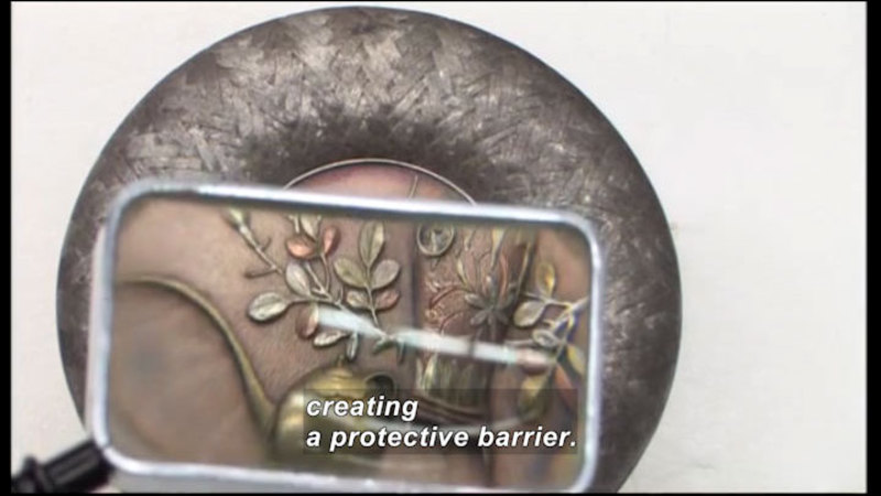 Magnified view of intricate metal work. Caption: creating a protective barrier.