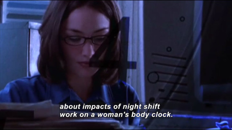 Woman in front of a computer screen in a dimly lit space. Caption: about impacts of night shift work on a woman's body clock.