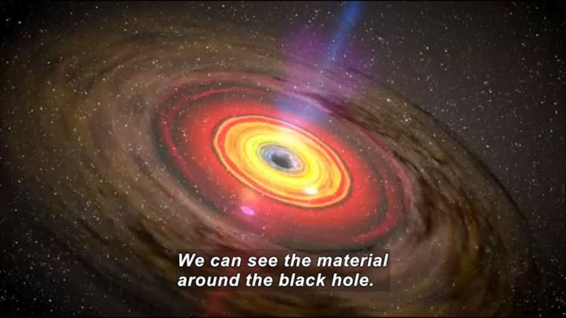 Concentric circles of light around a center of blackness. Caption: We can see the material around the black hole.