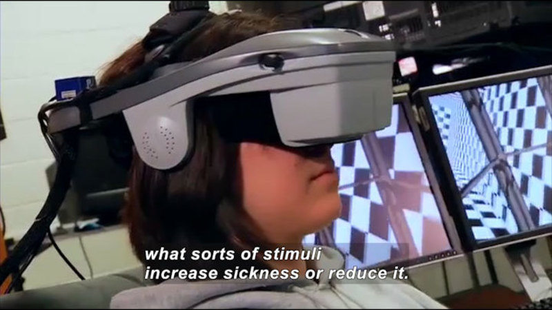 Person with a virtual reality headset on. Caption: what sorts of stimuli increase sickness or reduce it.