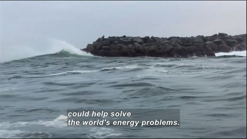 Waves striking a man-made jetty of rock. Caption: could help solve the world's energy problems.