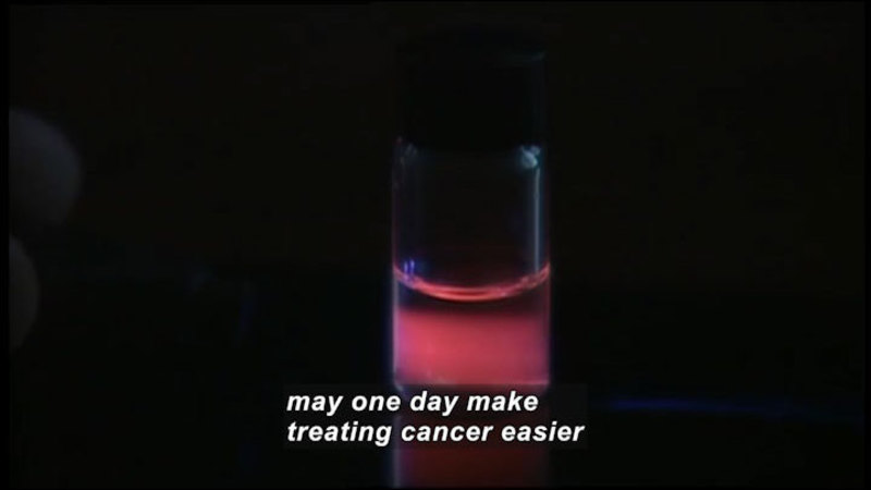 Clear vial with a glowing pink liquid. Caption: may one day make treating cancer easier