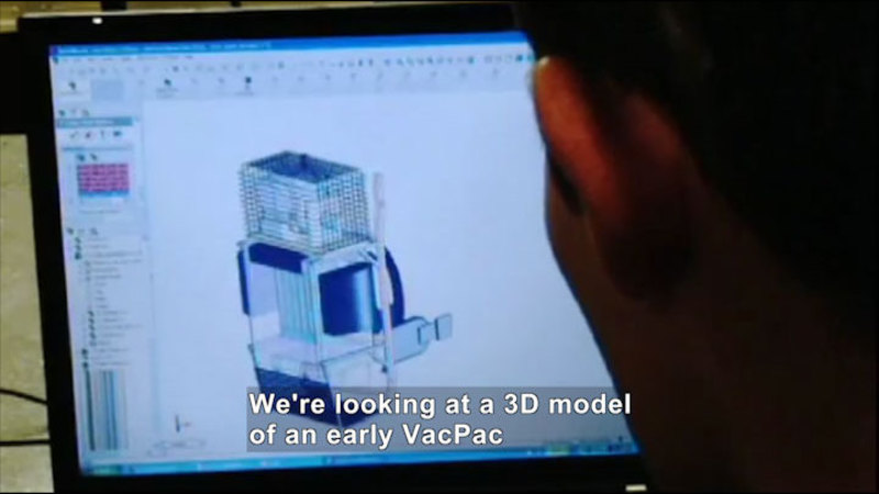 Person looking at a computer screen. Caption: We're looking at a 3D model of an early VacPac