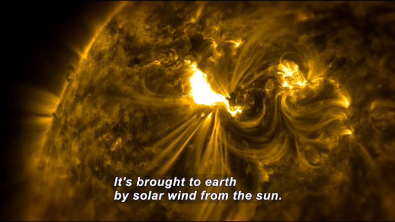Closeup of the surface of the sun showing disturbances caused by solar wind. Caption: It's brought to earth by solar wind from the sun.
