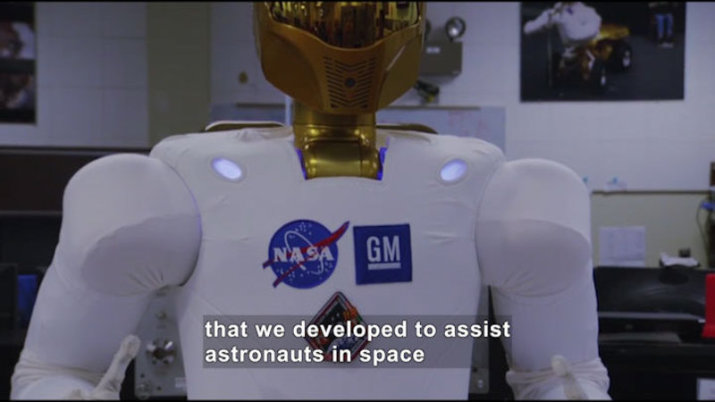 Robot with logos for NASA and GM. Caption: that we developed to assist astronauts in space